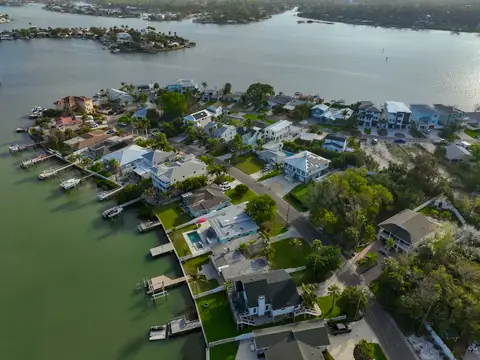 Golden-hour aerial showing the home's cul-de-sac waterfront location with panoramic water views.