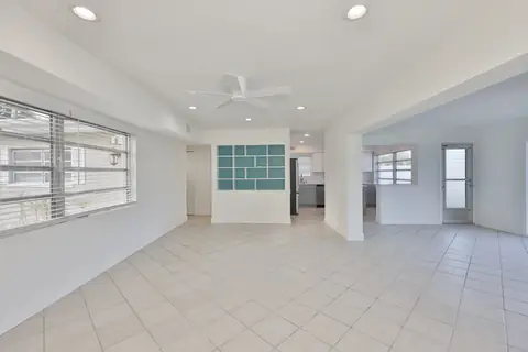 Open living room with tile floors and sliding doors leading to the waterfront patio.