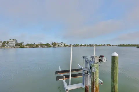 Private dock with boat lift overlooking the tranquil bayou with distant neighborhood homes.