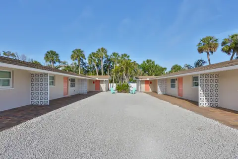 Interior courtyard view between the two bungalow units with turquoise chairs and palms.