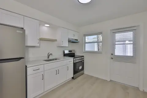 Updated kitchen with white shaker cabinets, stainless appliances and exterior door to the yard.