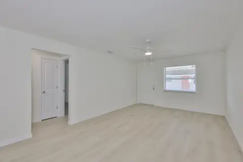Bright open living space with luxury vinyl plank floors and fresh neutral paint.