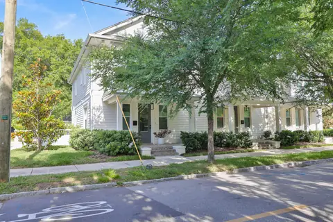 Front elevation showing the covered porch, magnolia tree and picket fence.