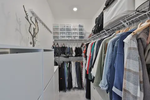 Spacious walk-in closet with custom shelving, drawers and shoe storage.