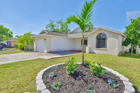 Front elevation with young palm and fresh landscape island at the entry.