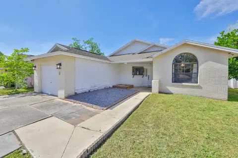 Straight-on view of the white brick facade, arched window and tile roofline.