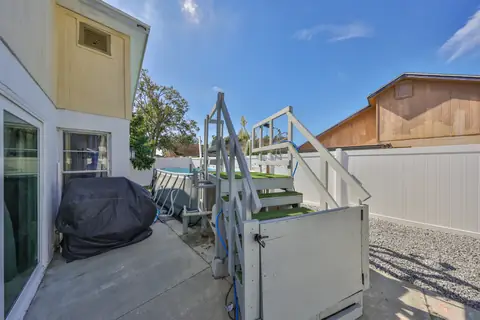 Fenced side yard patio with covered area and access to the backyard.
