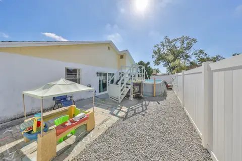 Fully fenced backyard with concrete patio, perfect for families and play.