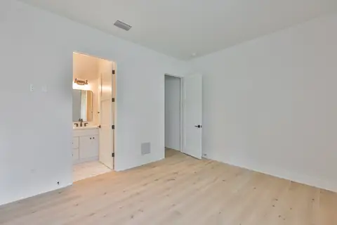 Bedroom with ensuite bath visible through the open door.