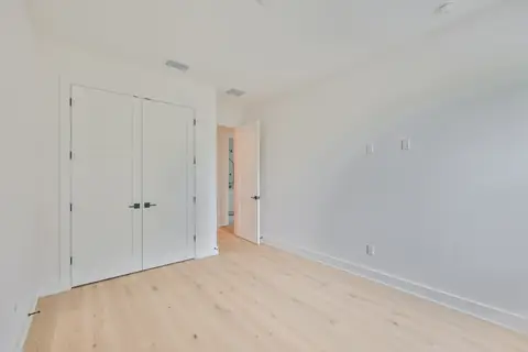 Primary bedroom entry showing closet, ensuite bath and coordinated finishes.