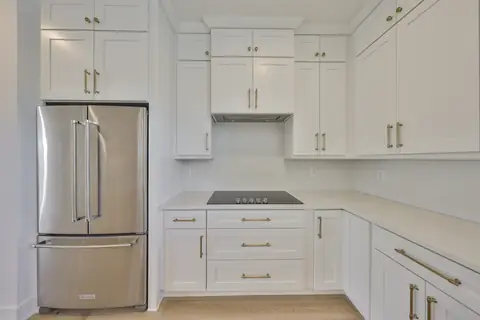 Kitchen detail showing the waterfall island, natural wood cabinetry and pendant lighting.
