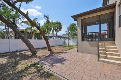 Side yard with paver walkway leading from the patio to the fenced backyard.