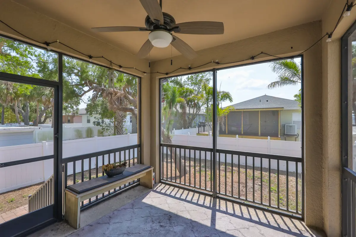 Screened covered lanai with ceiling fan and string lights at a South Tampa pool home