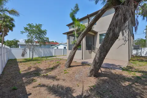 Spacious fenced backyard with mature oaks and direct patio access.