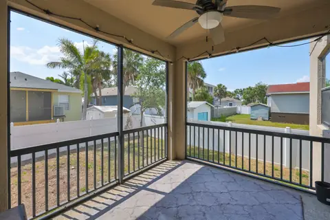 View from the screened porch overlooking the fenced backyard and neighbor homes.