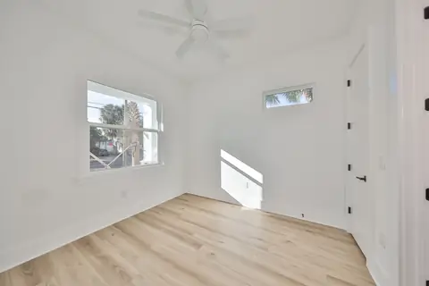 Secondary bedroom with oversized picture window, transom and fresh oak floors.