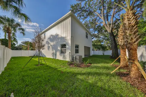 Rear view of the home showing the gable profile, fresh landscaping and privacy fencing.