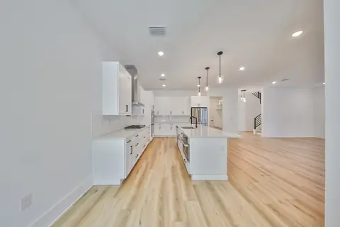 Great room with large sliders and open sight lines to the kitchen and dining area.