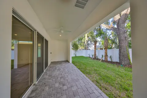 Covered back patio with paver deck and shaded ceiling fan overlooking the private backyard.