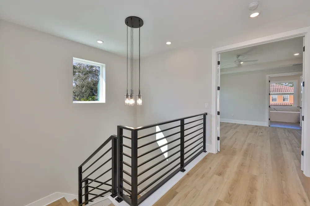 Open staircase with a black metal rail in a new South Tampa build